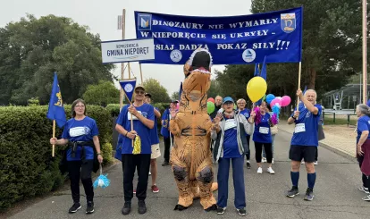 Olimpiada Seniorów Nieporęt 2026 - na zdjęciu reprezentacja gminy Nieporęt z maskotką - dinozaurem