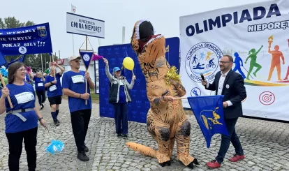 Olimpiada Seniorów Nieporęt 2026 - na zdjęciu reprezentacja gminy Nieporęt z maskotką - dinozaurem