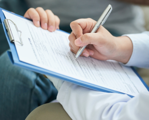 zdjęcie reki-nierozpoznawalnej-kobiety wypełniającej ankietę